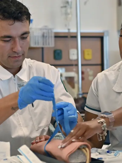 Female and male nursing students practicing a tourniquet