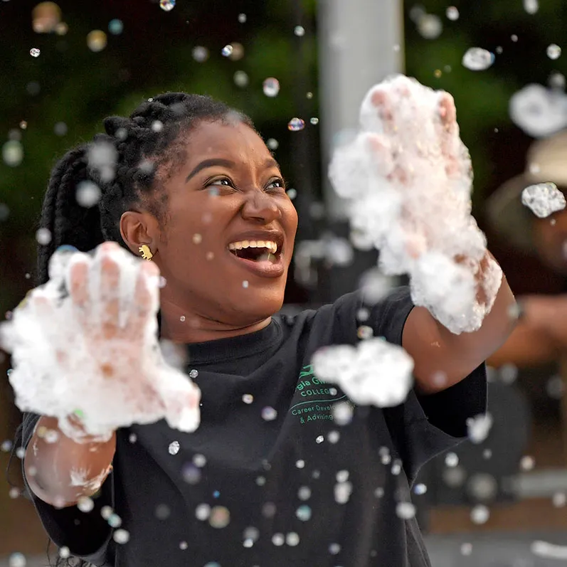 Resident student having fun with bubbles during a housing event