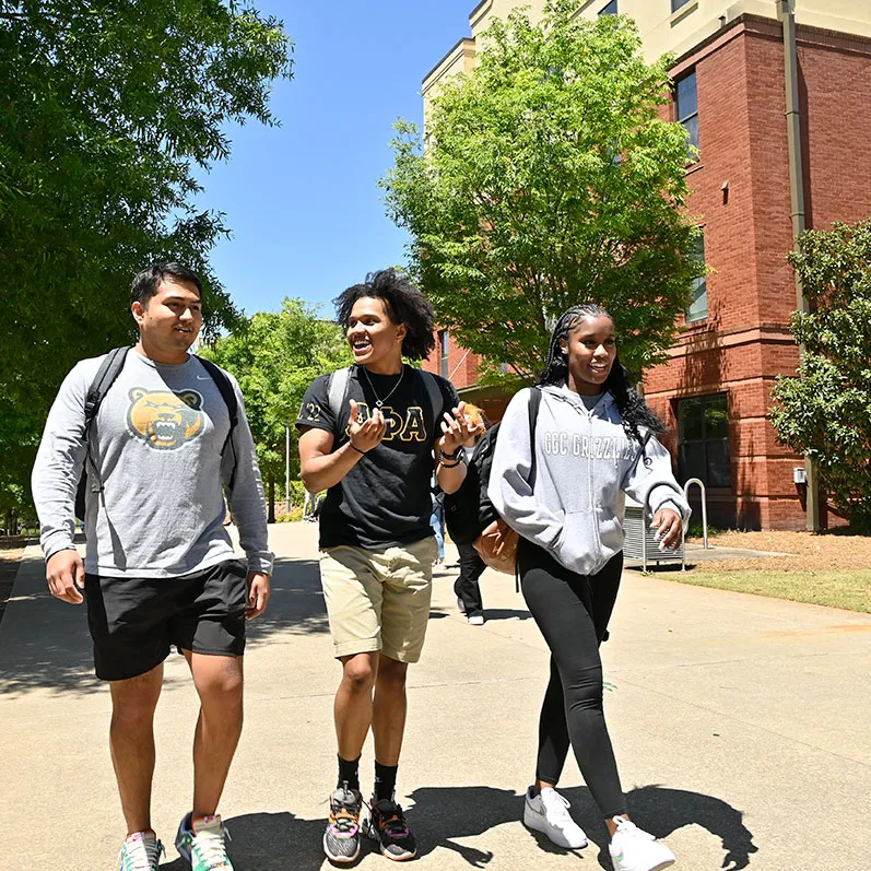 students walking near housing on a sunny day
