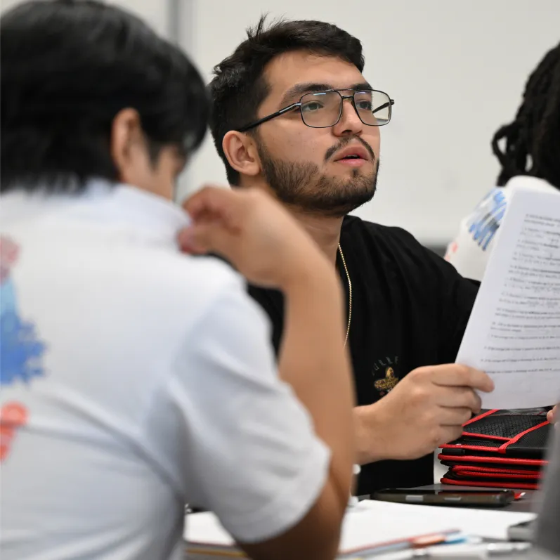 Student holding paper, looking up