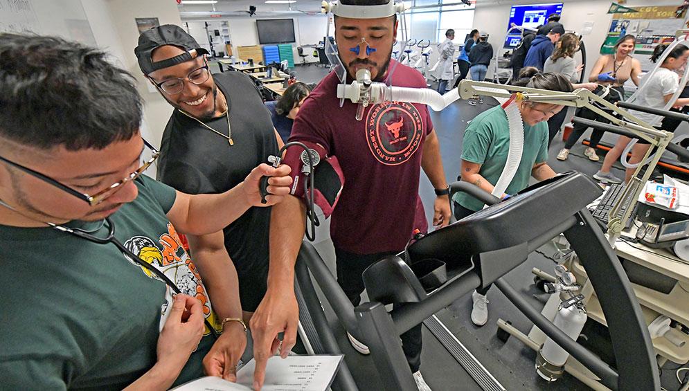 Exercise science students conducting assessment test on treadmill