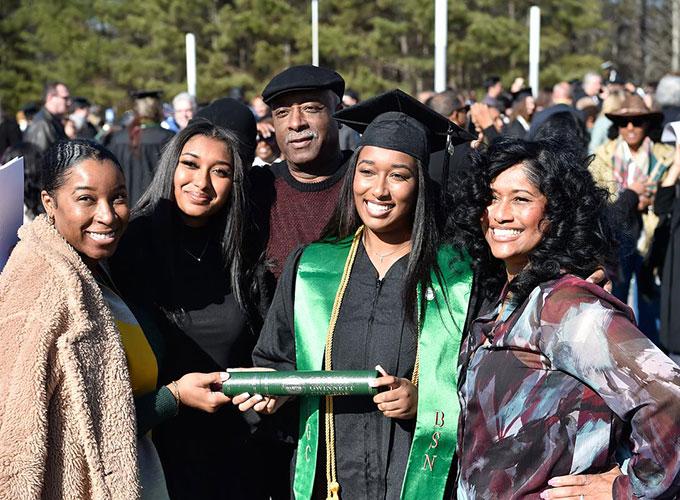 grad surrounded by family after graduation