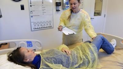Student helping patient in lab