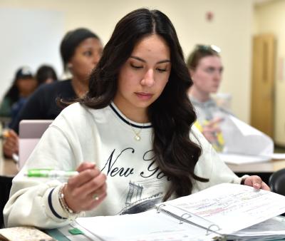 Student looking at her notes in class