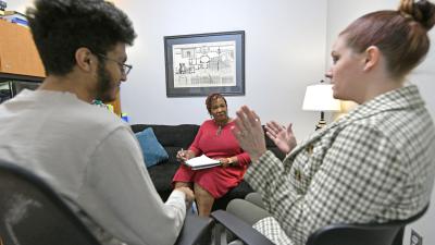 Three people in a room talking