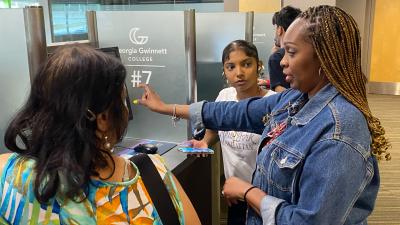 Woman talking to student and her parent