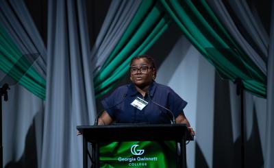 Nandi Green standing at podium giving a testimonial at the GGC Four Pillars Scholarship Gala
