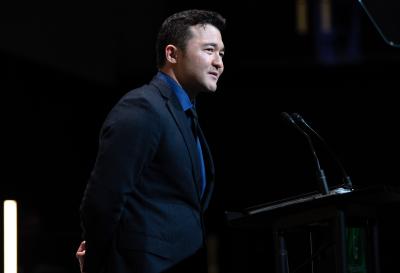 Daulet Sopan standing at podium giving a testimonial at the GGC Four Pillars Scholarship Gala