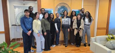 A group photo of student assistants with President Jann Joseph posing an office